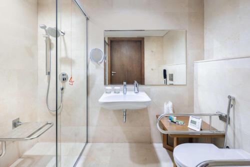 a bathroom with a sink and a glass shower at Al Andalus Mall Hotel in Jeddah