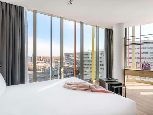 a bedroom with a white bed and a large window at ibis Budapest Stadium in Budapest