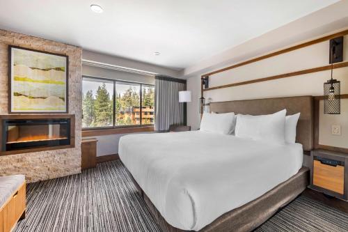 a hotel room with a large bed and a fireplace at Hilton Vacation Club Tahoe Seasons Lake Tahoe in South Lake Tahoe