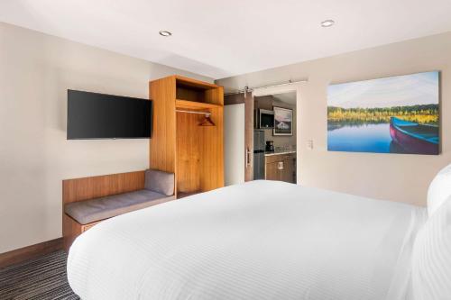 a bedroom with a large white bed and a flat screen tv at Hilton Vacation Club Tahoe Seasons Lake Tahoe in South Lake Tahoe