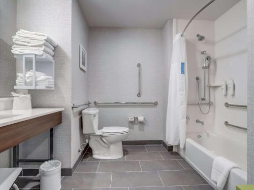 a bathroom with a toilet and a tub and a sink at Hampton Inn & Suites Cincinnati Midtown Rookwood in Cincinnati
