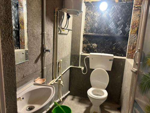 a small bathroom with a toilet and a sink at Tapama Resort Bakkhali in Bakkhali