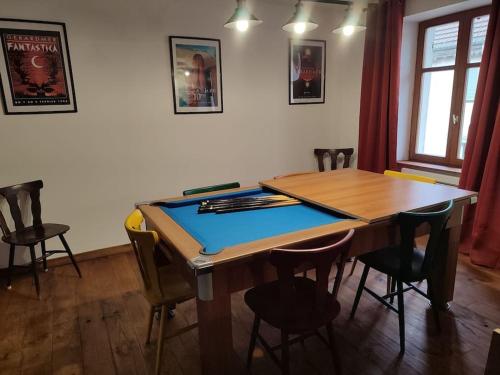 una mesa de ping pong en una habitación con sillas en Logement Spacieux, en Fraize