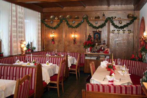 ein Esszimmer mit 2 Tischen und Weihnachtsdekorationen in der Unterkunft Hotel Edelweiss in Fügen