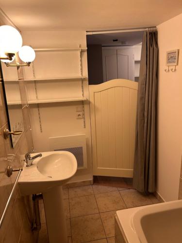 a bathroom with a sink and a mirror and a tub at Coeur de Bastide in Villeneuve-sur-Lot