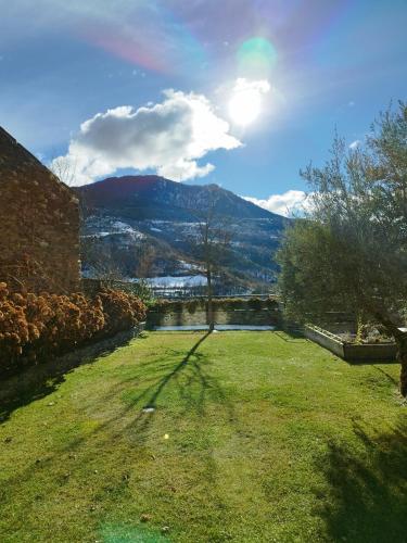 a grassy yard with a view of a mountain at Casa Rural La Comella in Tirvia