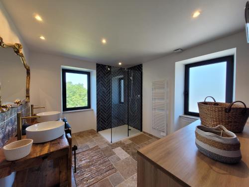 une salle de bain avec deux lavabos et une douche dans l'établissement Gite de la Quiétude, à Donzenac