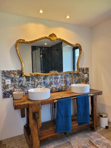 une salle de bain avec deux lavabos et un miroir dans l'établissement Gite de la Quiétude, à Donzenac