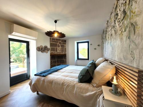 - une chambre avec un lit et un grand mur dans l'établissement Gite de la Quiétude, à Donzenac