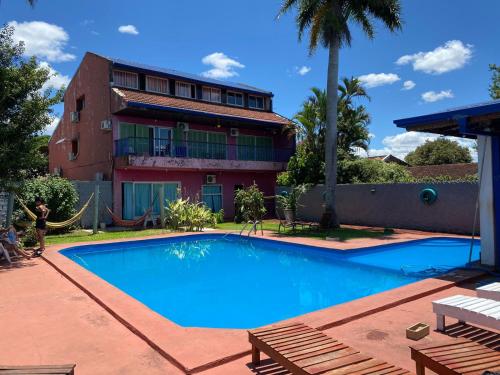 a swimming pool in front of a building at Guembe al Rio Hostel in Puerto Iguazú