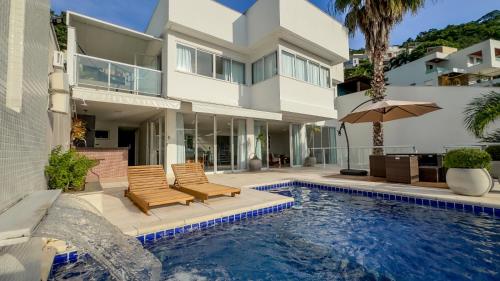 uma casa com piscina em frente a uma casa em Mansão & Loft Exclusivo Vista Mar em Niterói