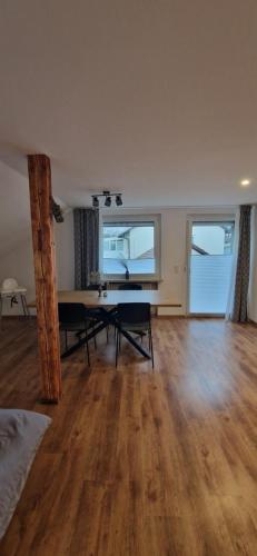 an empty living room with a table and two windows at Zum weißen Stein in Bad Arolsen