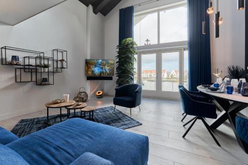 a living room with a blue couch and a table at Captains Boathouse in Harderwijk