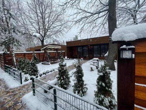 un cortile coperto da neve con alberi e una casa di Гостевой комплекс "Дядя Саша" a Sokirno
