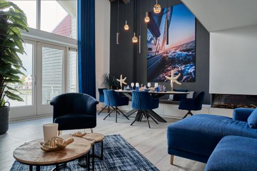 a living room with a blue couch and a table at Captains Boathouse in Harderwijk