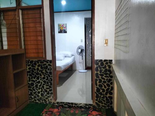 - une salle de bains avec un miroir et une chambre avec un lit dans l'établissement Brenmariel Tourist Inn, à El Nido