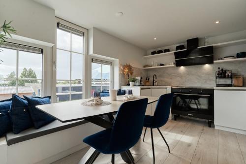a kitchen with a table and some blue chairs at Captains Boathouse in Harderwijk