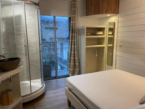 een slaapkamer met een bed en een raam met een balkon bij Les remparts in Luz-Saint-Sauveur