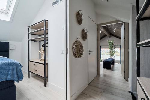 a bedroom with a door leading into a room with a bed at Captains Boathouse in Harderwijk