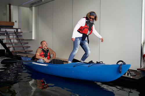 a woman standing on top of a blue canoe at Captains Boathouse in Harderwijk