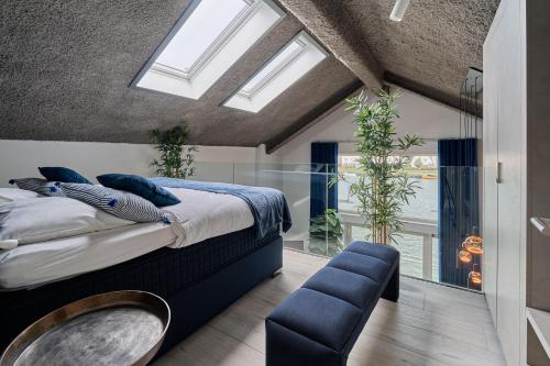 a bedroom with a large bed and a large window at Captains Boathouse in Harderwijk