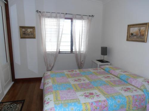 a bedroom with a bed and a window at Floriana Villas in Cairns