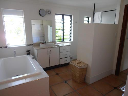 a bathroom with a white tub and a sink at Floriana Villas in Cairns