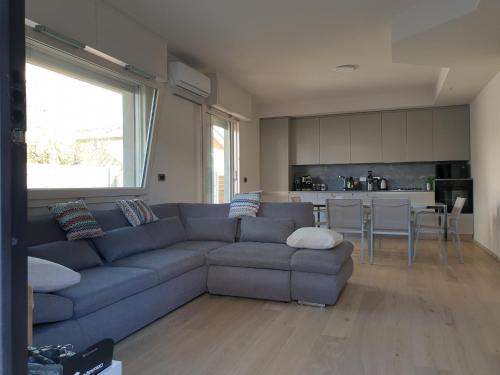 a living room with a blue couch and a kitchen at Potenza Suite Home in Riccione