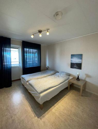 a bedroom with a bed and a table in it at Rentalux Apartments in Örnsköldsvik in Örnsköldsvik
