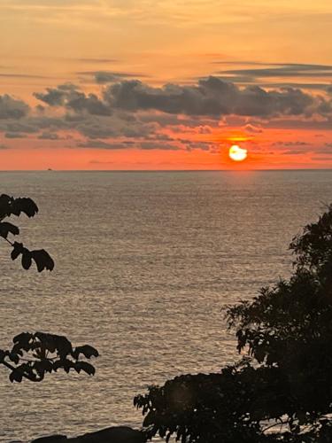 a sunset over the ocean with the sun setting at CASA DE TUCA in Ilhabela