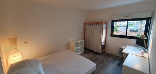 une petite chambre avec un lit et une télévision dans l'établissement Idéal couple Appartement 1 chambre Cosy et calme pour visiter Nantes, à Nantes