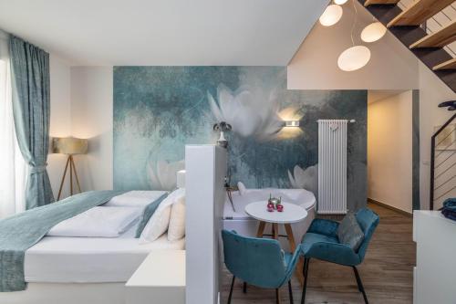 een slaapkamer met een bed en een tafel en stoelen bij Maison Valentina in Merano