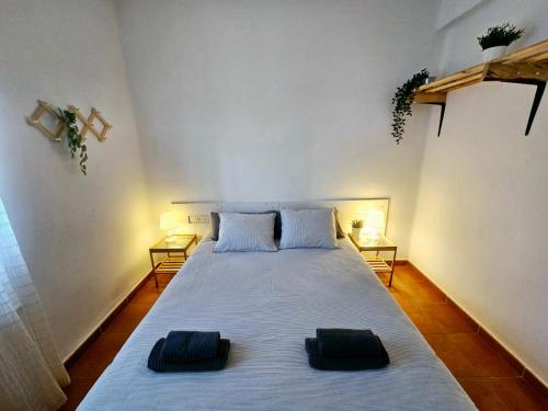 a bedroom with a large bed with two pillows on it at Chalet con piscina y barbacoa, Valencia in Torrent