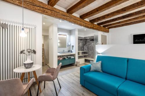 a living room with a blue couch and a table at Maison Valentina in Merano
