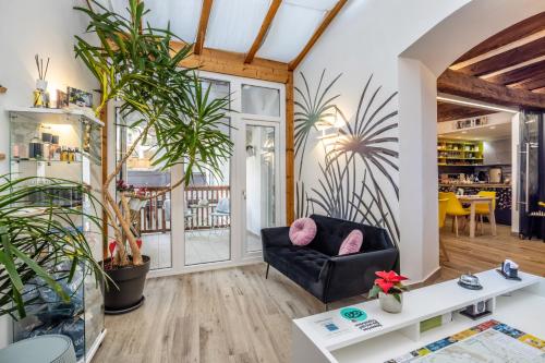 a living room with a black couch and plants at Maison Valentina in Merano