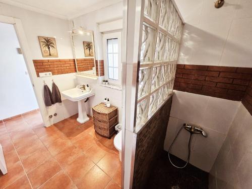 a bathroom with a sink and a toilet and a mirror at Chalet con piscina y barbacoa, Valencia in Torrent