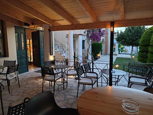 a patio with tables and chairs and a staircase at Elanthi Village Apartments in Kalamaki