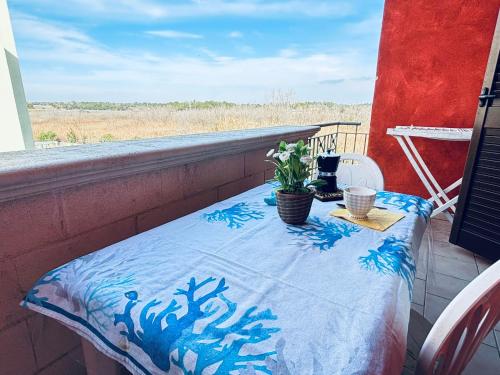 un tavolo su un balcone con coperta blu e bianca di Gallipolitravel Residence Baia Verde a Gallipoli