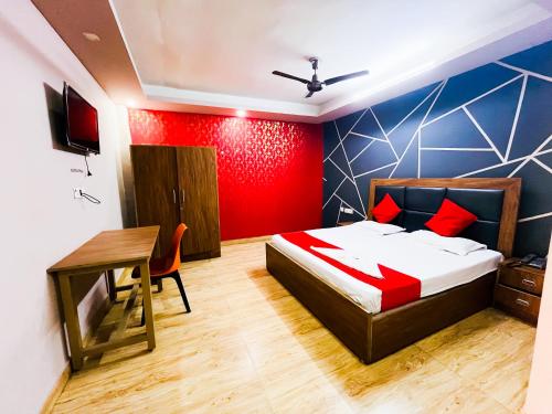 a bedroom with a bed and a table and a desk at Comfort Inn Nizamuddin Railway Station 2 Min Walk in New Delhi