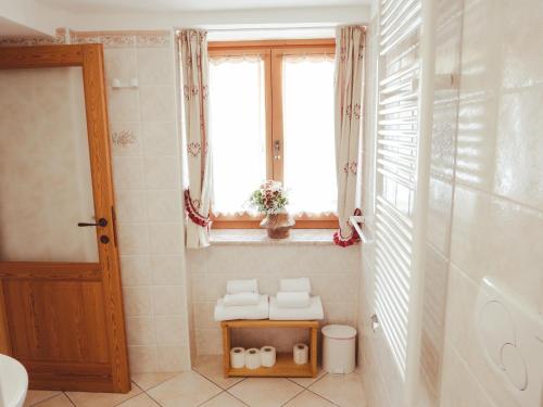 a bathroom with a toilet and a window and a sink at La Majon de Fohten in Montjovet