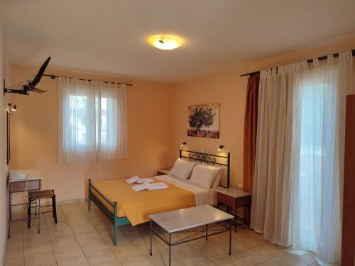 1 dormitorio con 1 cama con colcha amarilla en Elanthi Village Apartments, en Kalamaki