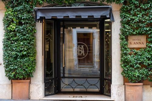 a black door on a building with plants at Hotel S. Anna in Rome