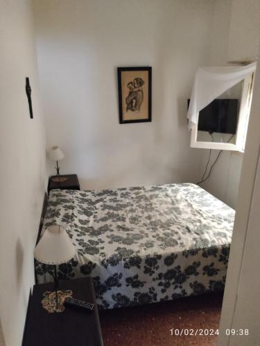 um quarto com uma cama e uma mesa com um candeeiro em Alquiler Temporada Casa 2 dormitorios para 6 personas em Mar del Plata