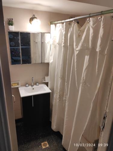 uma casa de banho com uma cortina de chuveiro e um lavatório em Alquiler Temporada Casa 2 dormitorios para 6 personas em Mar del Plata