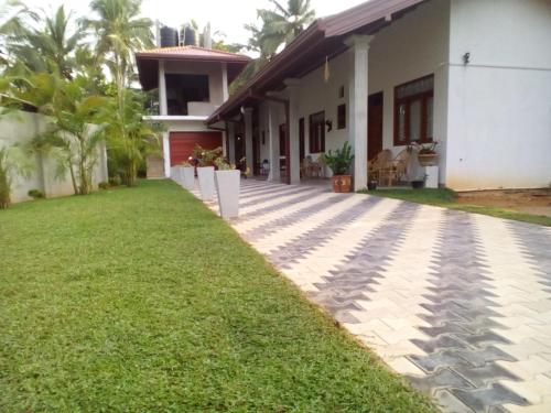 a house with a lawn in front of it at Orchid Dream in Bentota