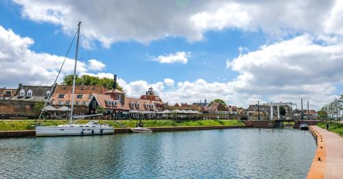 a boat docked on a river in a city at Captains Boathouse in Harderwijk