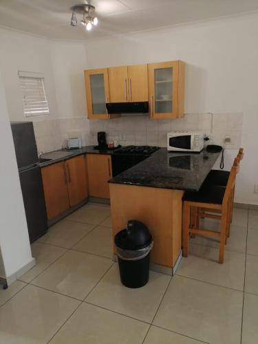 a kitchen with wooden cabinets and a counter top at Airport Inn and Suites in Johannesburg