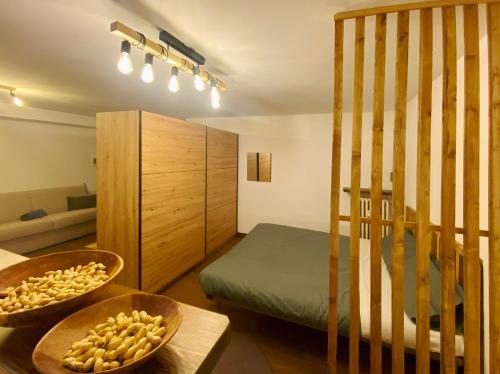 CremenoにあるMonolocale con bagno turco e spazio esterno Studio apartment with turkish bath and external spaceのベッドとテーブルの上に食べ物の入ったボウルがある部屋