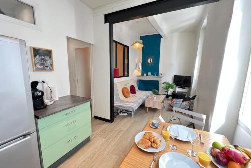 d'une cuisine et d'un salon avec une table et de la nourriture. dans l'établissement Charme Authenticité à Marseille, Camas, à Marseille