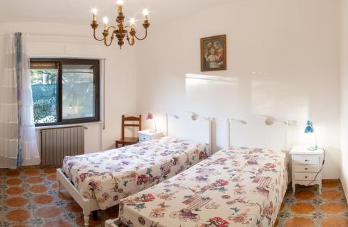 a bedroom with two beds and a chandelier at Da Ernestina in Imperia